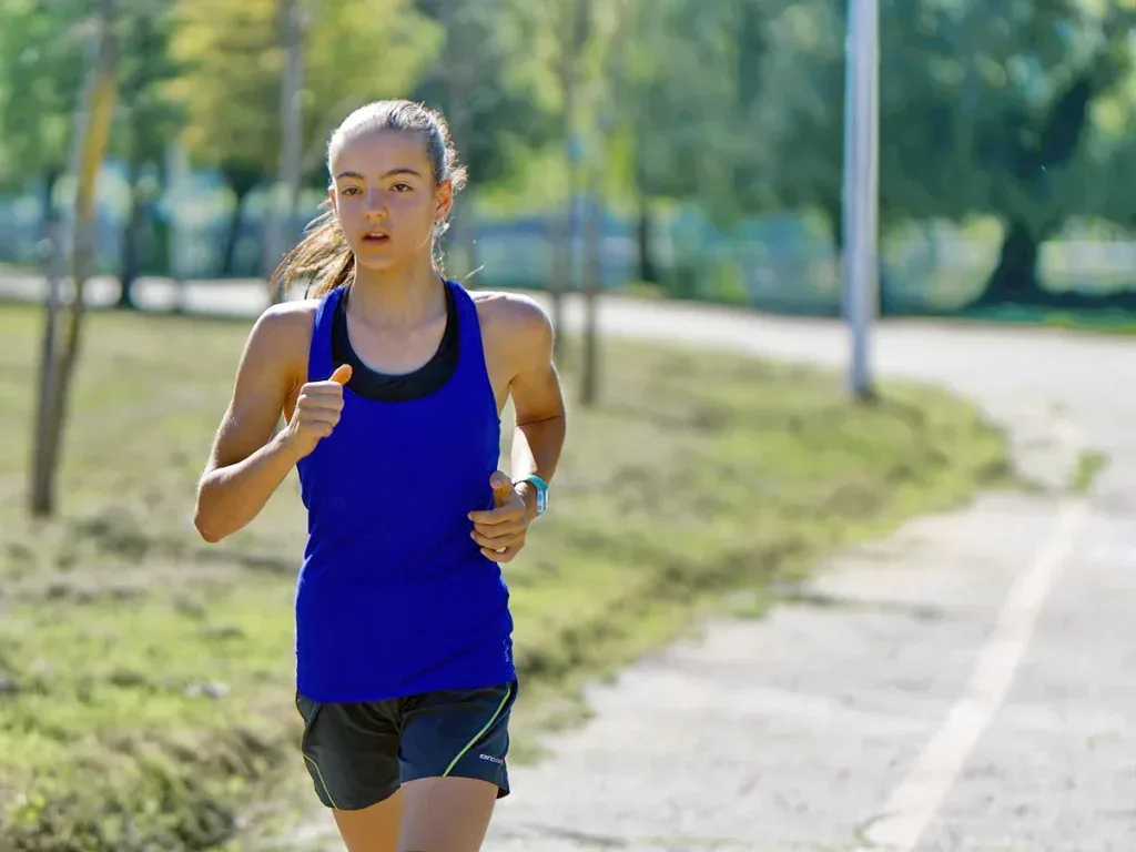 Biegaczka w parku podczas treningu do biegu na 10 km i półmaratonu