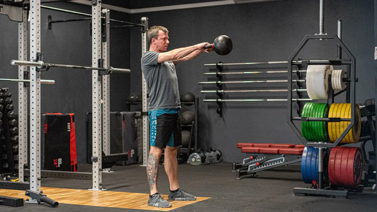 Kettlebell ćwiczenia dla mężczyzn: swing oburącz w górnej fazie, biodra w pełnym wyproście
