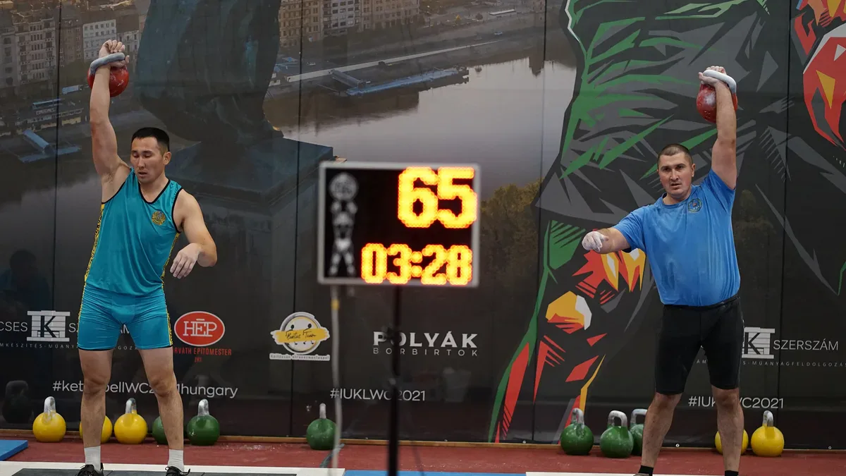 Kettlebell hardstyle i girevoy sport: dwóch zawodników w rwaniu na mistrzostwach świata, tablica z liczbą powtórzeń