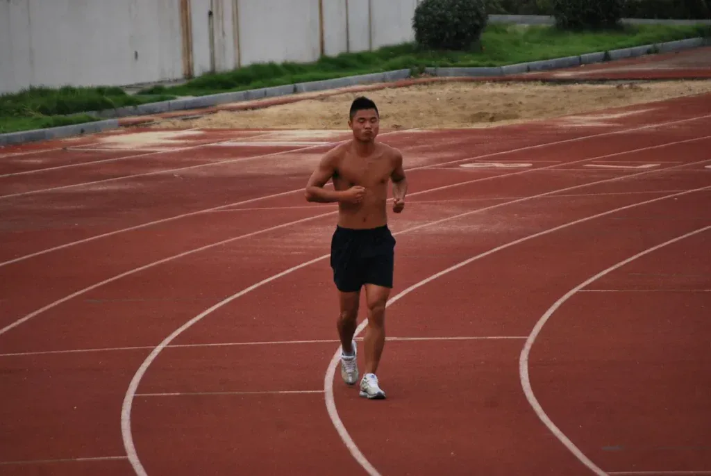 Test Coopera: biegacz w równym tempie na bieżni lekkoatletycznej