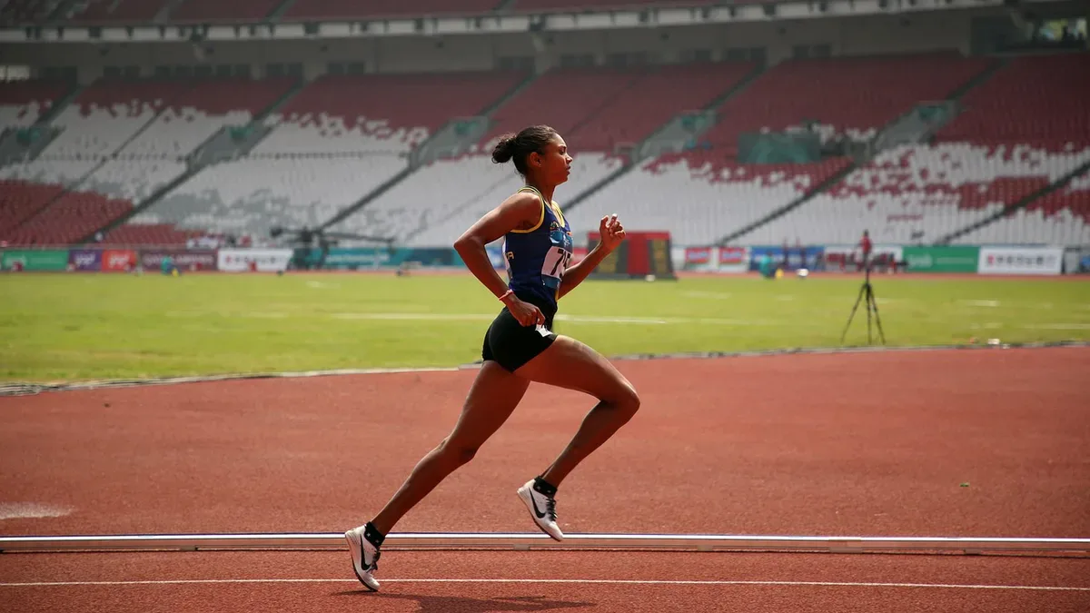 Biegaczka na bieżni stadionu podczas 12-minutowego testu Coopera